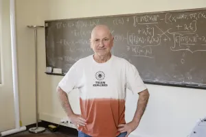 Larry Wasserman in front of a blackboard covered in equations