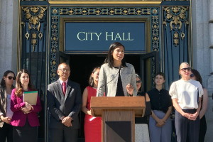 Breanna Zwart speaks at a podium in front of City Hall